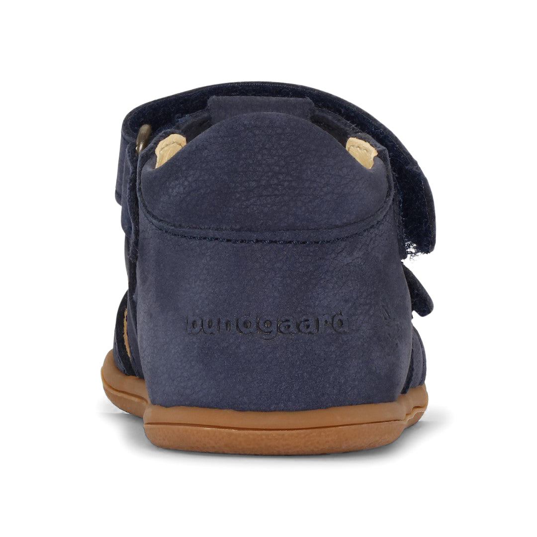 Unisex børnesandal fra Bundgaard i model Balder, Navy. Sandalen viser en barfodsvenlig design med en fleksibel sål og en mørkeblå læderoverdel, bagfra.