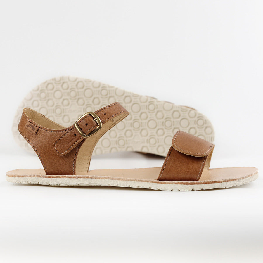 Tikki Vibe sandaler til kvinder i varianten Cream, fremvist med justerbar spændelukning og Velcro. Perfekte til barfodsgang med en sål på 6mm fra Vibram Supernewflex for bedre stabilitet.