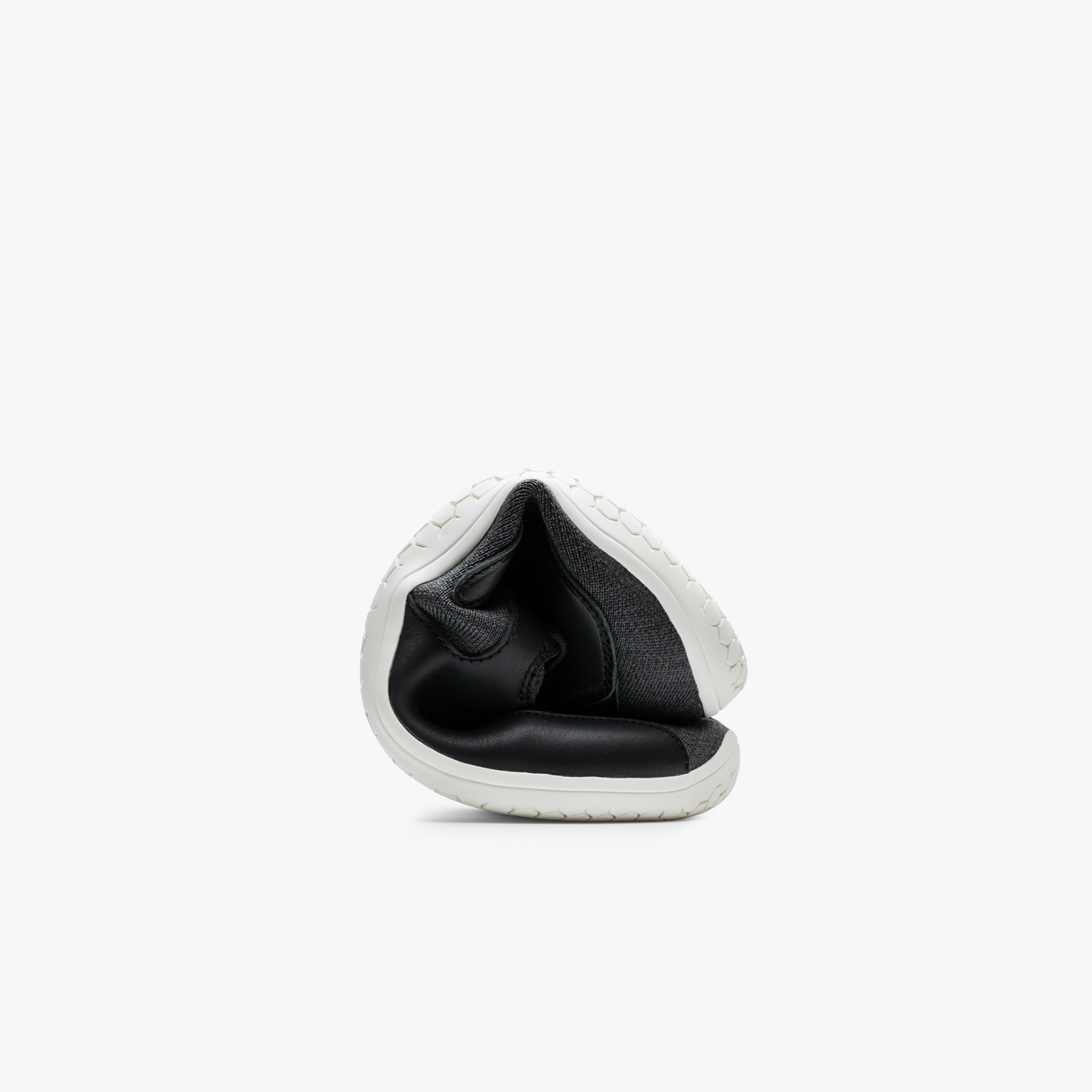 Sammenfoldet Vivobarefoot Asana III sko i varianten Obsidian viser fleksibiliteten og lette design, ideel til rejser og daglig komfort.