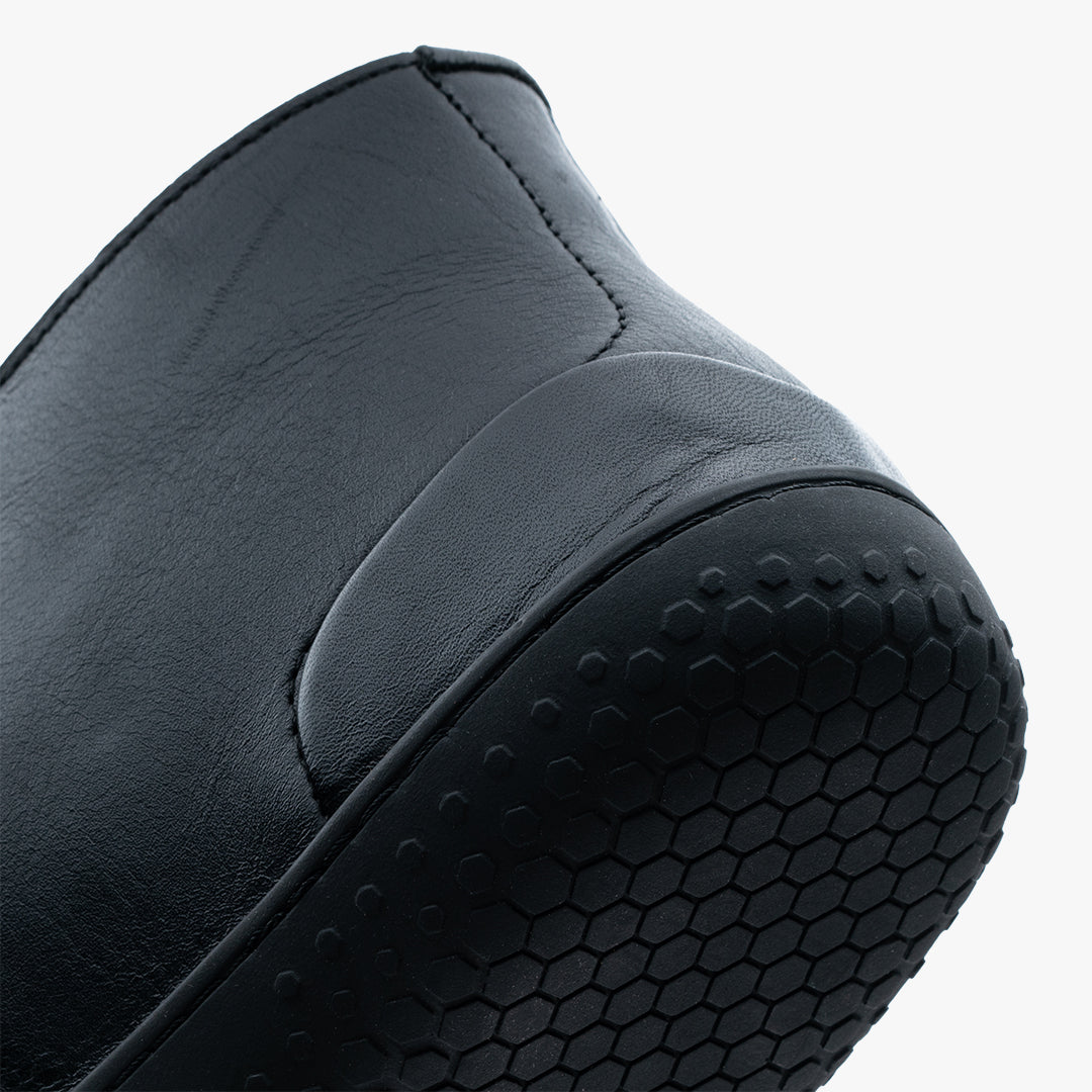 Nærbillede af Vivobarefoot Gobi Lux sko i varianten Obsidian, der viser metalfrilæder og sekskantet ydersålsmønster for bedre jordforbindelse.