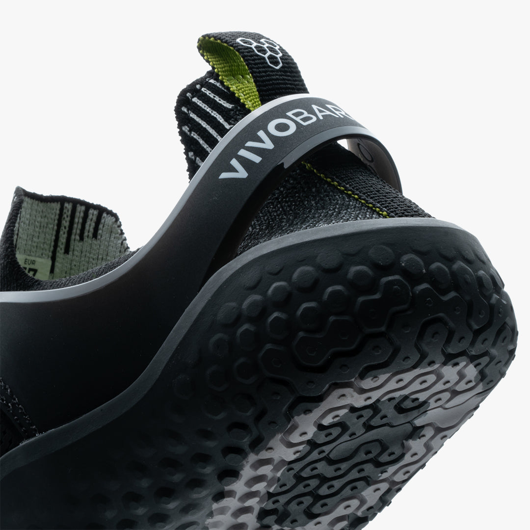 Vivobarefoot Motus Strength Womens sko i varianten Obsidian / Grey, med detaljerede knopper på sålen for fortrinligt greb og en smidig strikket overdel i grøn og sort. Designet til bevægelsesfrihed og styrke.