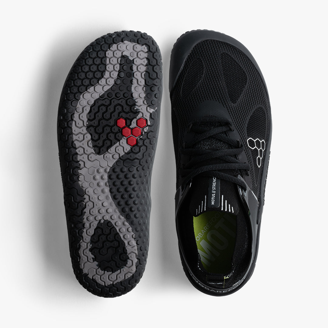 Vivobarefoot Motus Strength Womens i Obsidian / Grey, visning af toppen og sålen. Skoene fremviser en detaljeret sort mesh-overdel og en sål med specialdesignet mønster for optimalt greb.